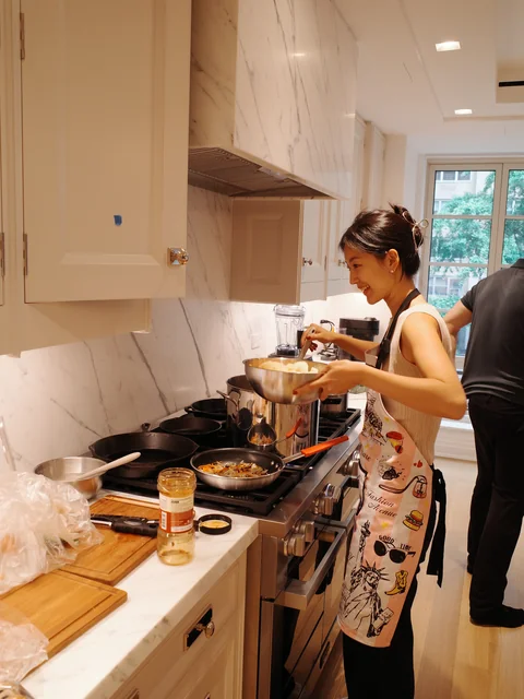Yeaji wearing an apron and cooking at the stove for a Chuseok gathering